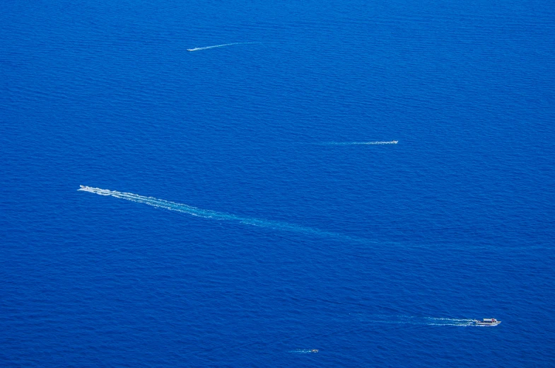 two boats floating in a big blue body of water