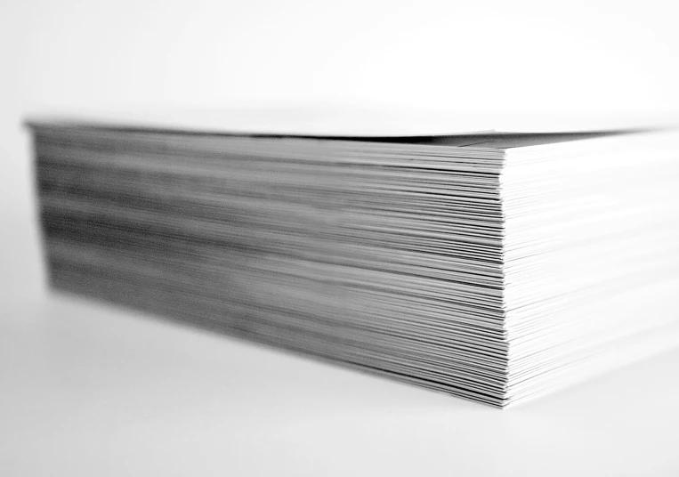 a stack of white papers in a black and white po