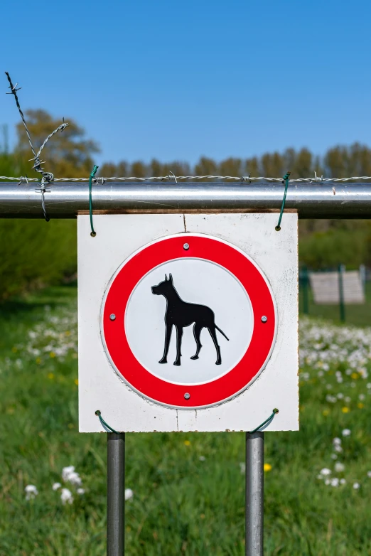 a white and red sign hanging on a metal pole