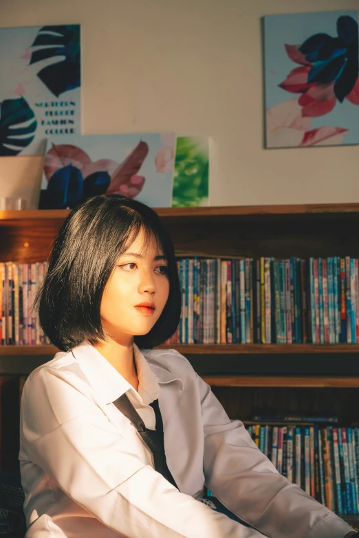 a woman with her hands folded in front of a book shelf