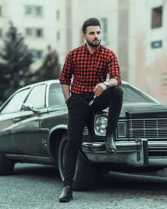 a man sitting on the hood of a car