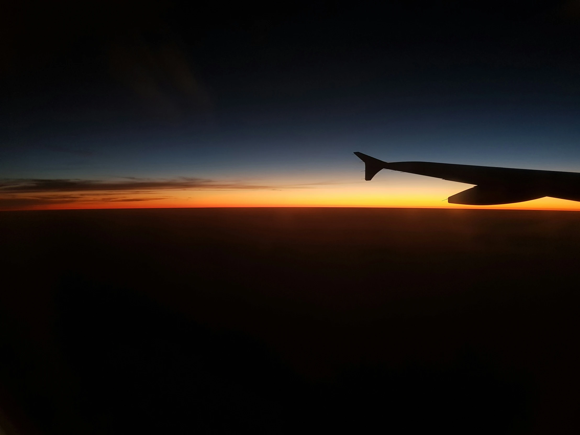 sunset from the air showing a airplane wing