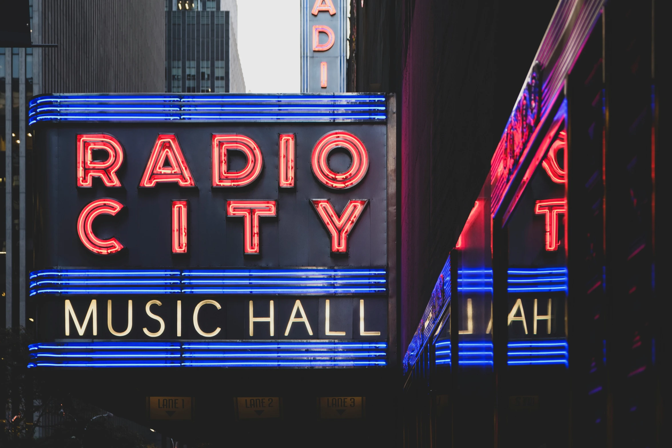 a radio city music hall neon sign on a street