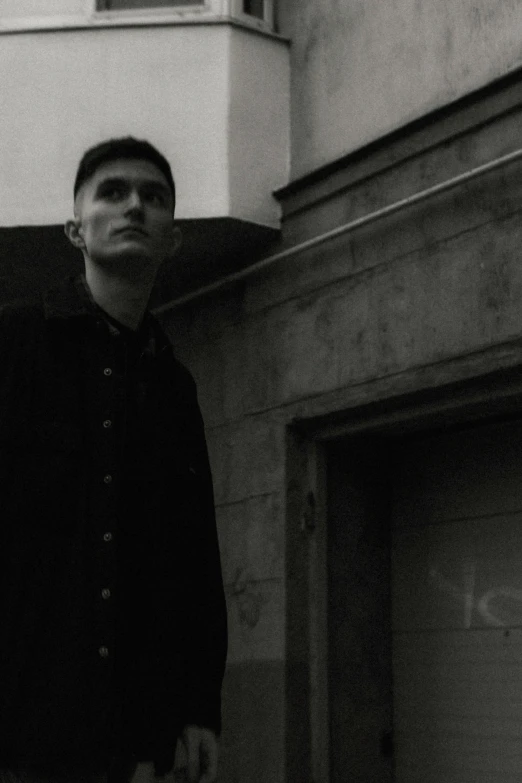 a young man standing in front of a tall building