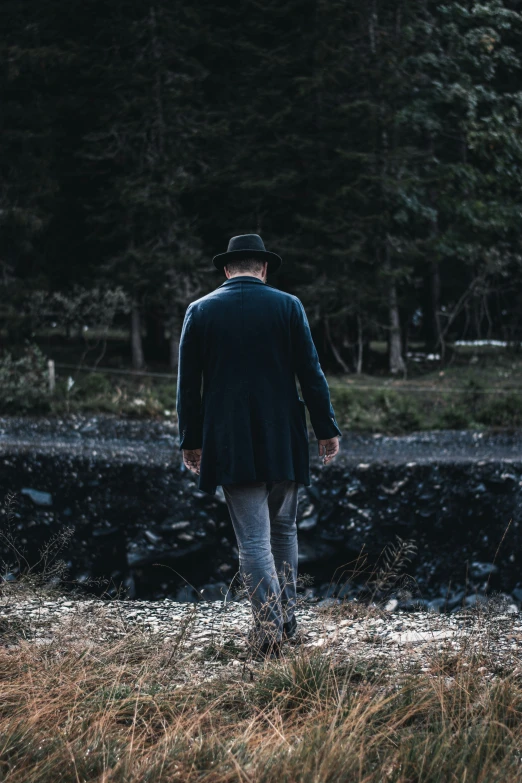 the man is walking along by some water