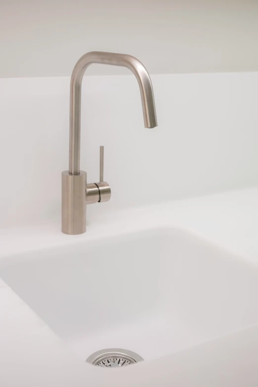 a metal sink faucet mounted to a wall