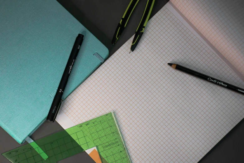 notebook with ruler, rulers and pens on it