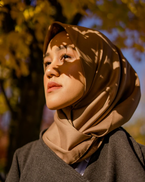 a young woman wearing a headscarf is looking back