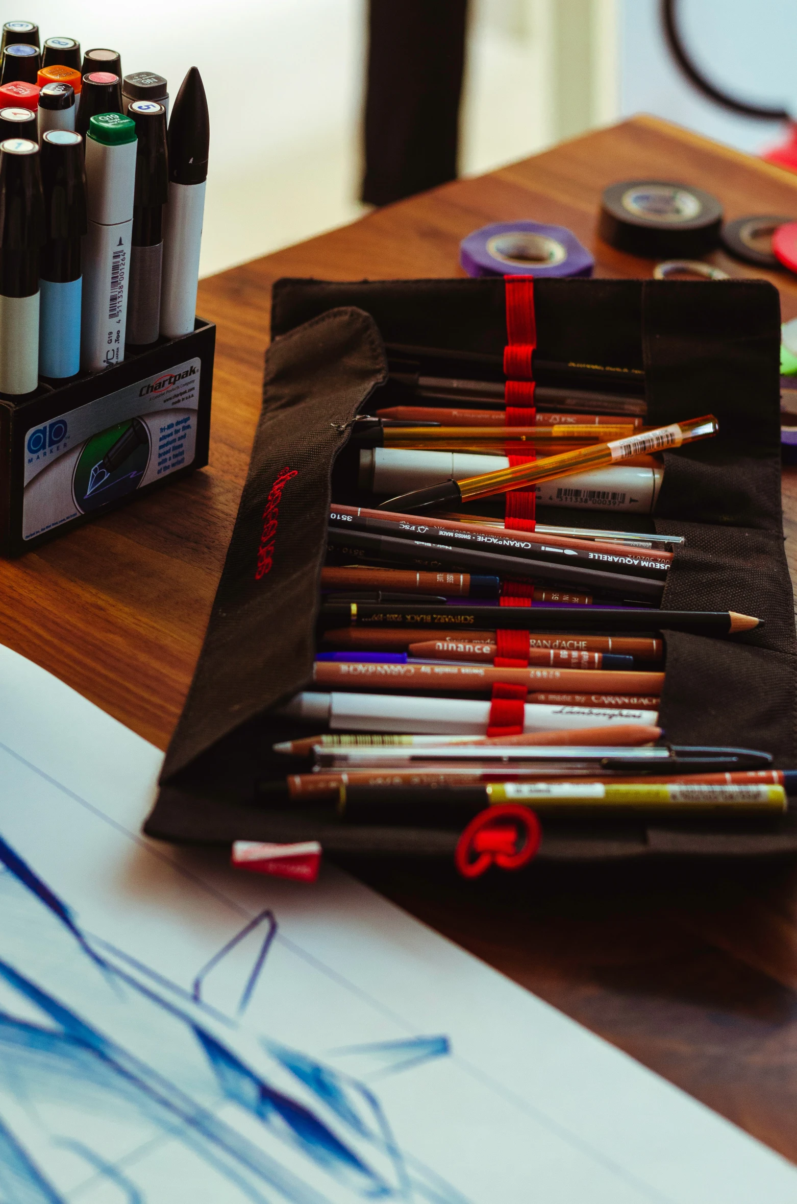 art supplies such as pens, markers and markers sit on a table