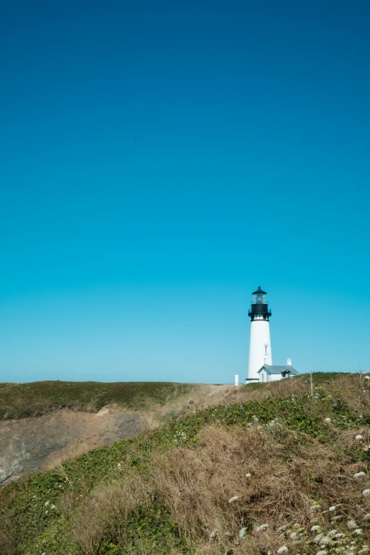 lighthouse on top of hill in distance with sky