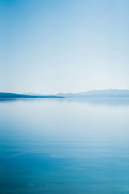 view of the vast blue water and sky with mountains