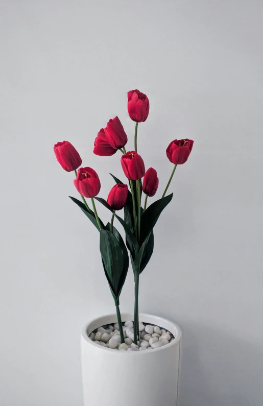 small flower arrangement in modern white planter with stones