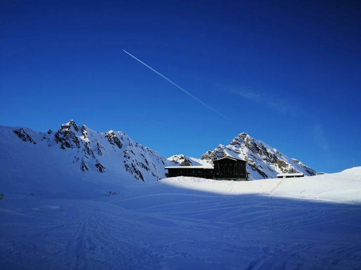 a small wooden house in the mountains covered by snow