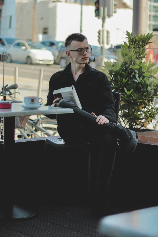 two men sit at a table with their books