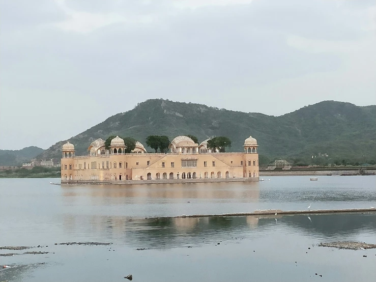 a large house sits in the middle of a body of water