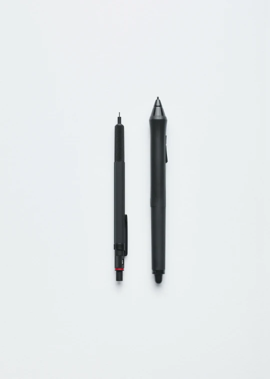 a pen and a rollerpoint marker sitting on a white surface