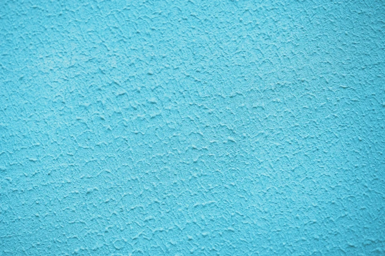 a large blue wall has tiny black dots