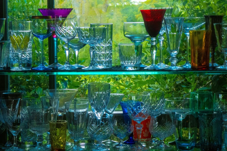 many glasses on top of a glass shelf