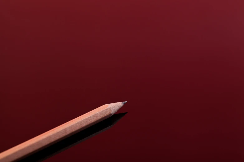 a pencil standing with its tip pointing towards the ground