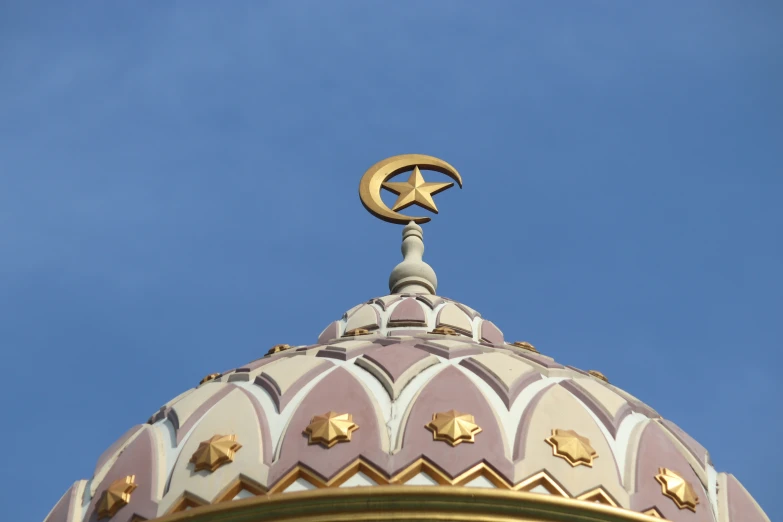 the top of a building with a gold star and crescent on top