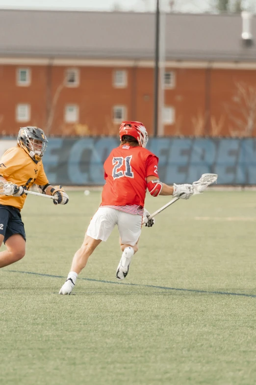 a couple of guys are playing a game of lacrosse