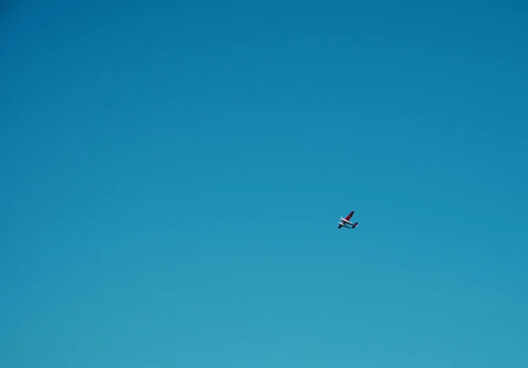 a plane flying in the sky, high up above the clouds