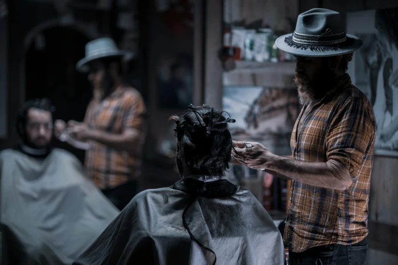 two men who are  their hair in a barber shop