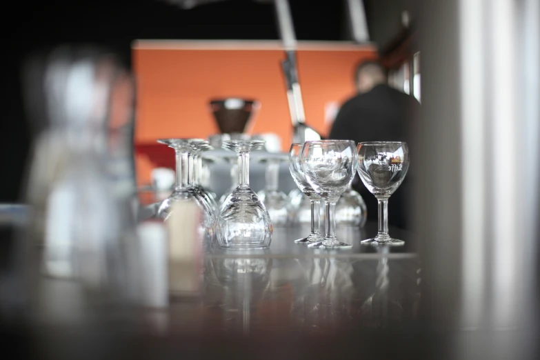 multiple wine glasses lined up on a counter