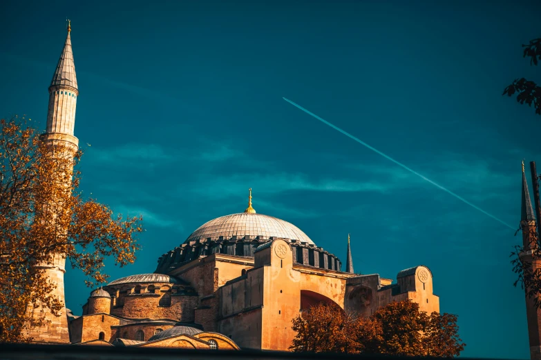 an airplane flying in the sky past an old building