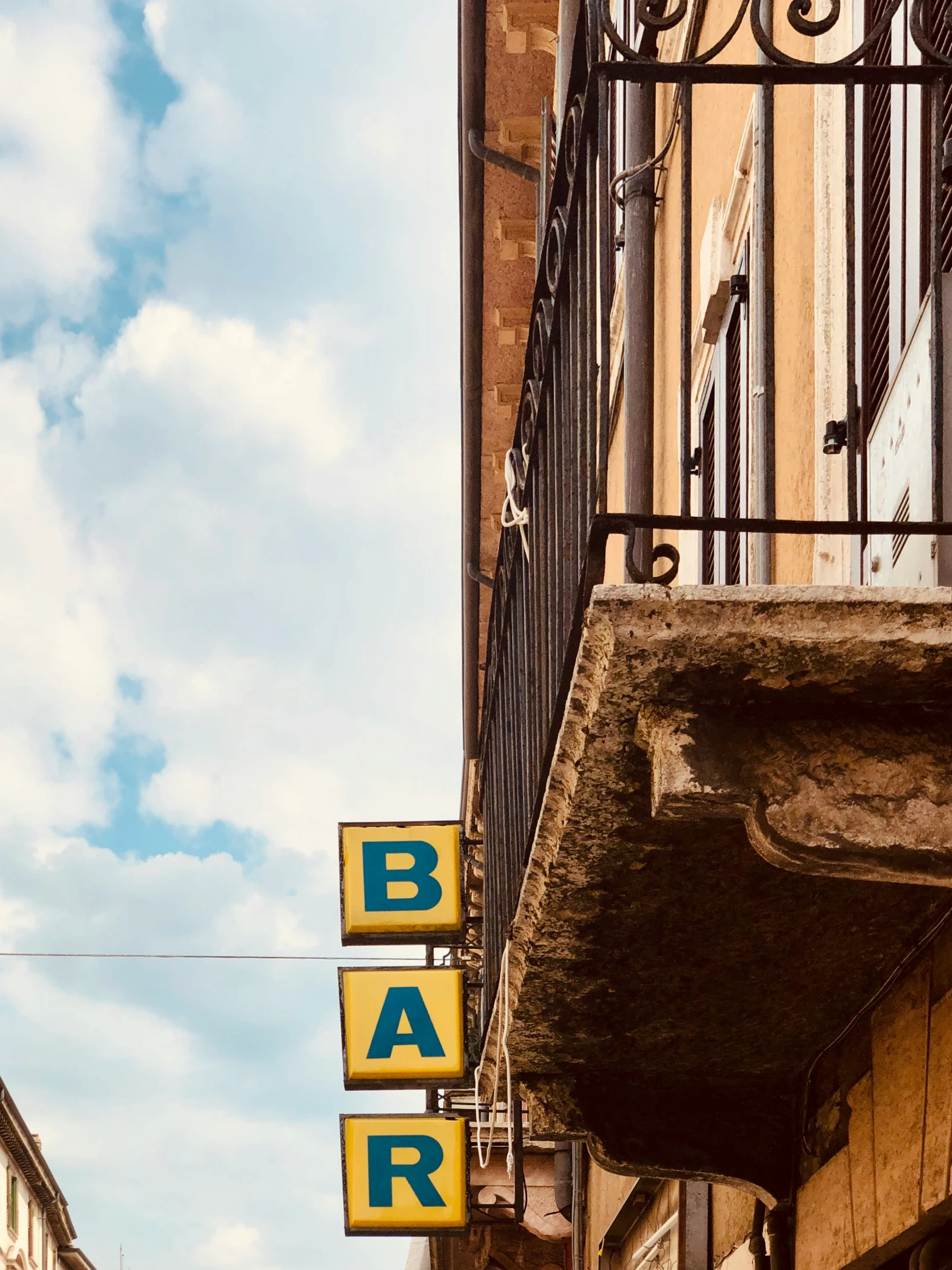 an outside cafe sign on the corner of a building