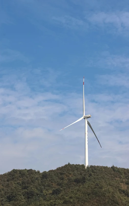 a white wind turbine on top of a hill
