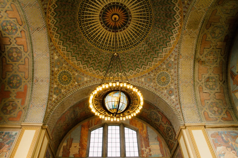 the interior of a building with a large round mirror hanging over it