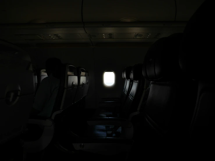 a man standing in an airplane aisle area