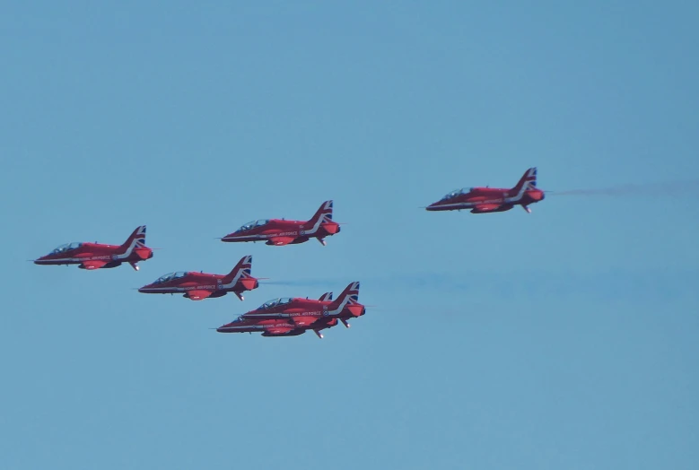 a group of four fighter jets flying through the sky