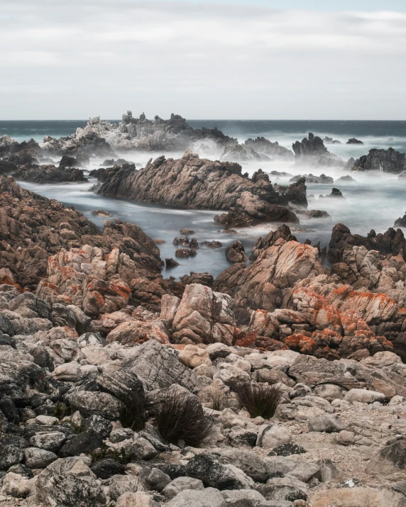 rocks by the ocean with water on the ground