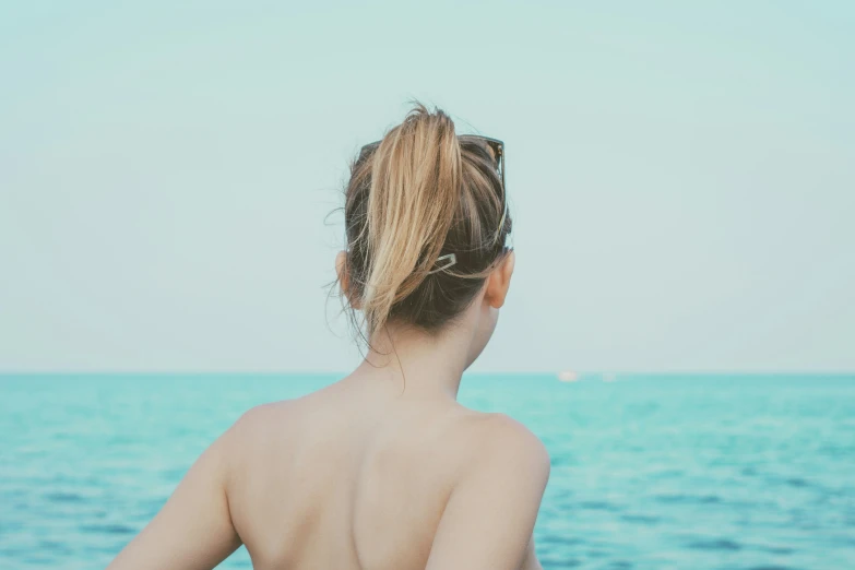 a woman's hair is in the middle of her body, from behind