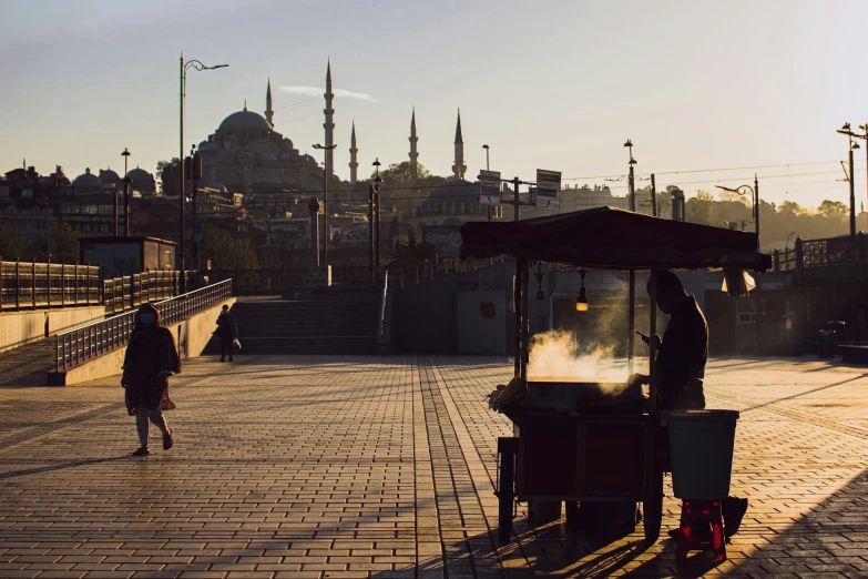 a man selling food on a street in the evening