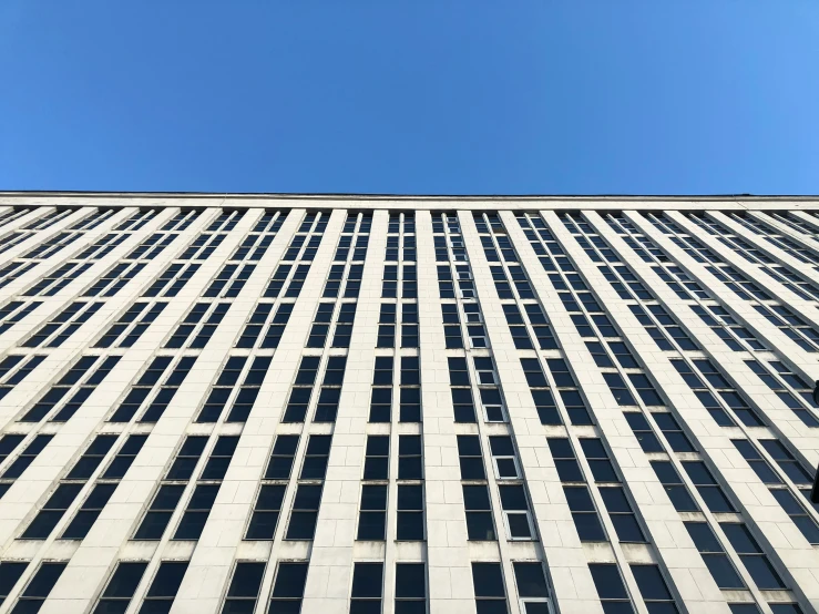 a tall building with multiple windows and some sky