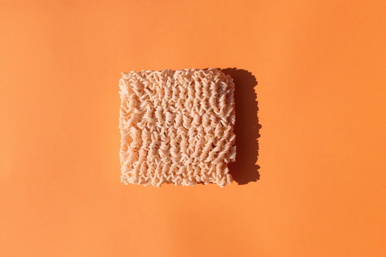 a square object that is sitting on top of an orange surface