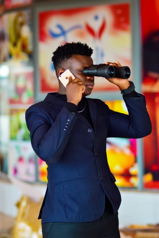 a man in a blue jacket, black pants, and black shoes holding a phone to his ear