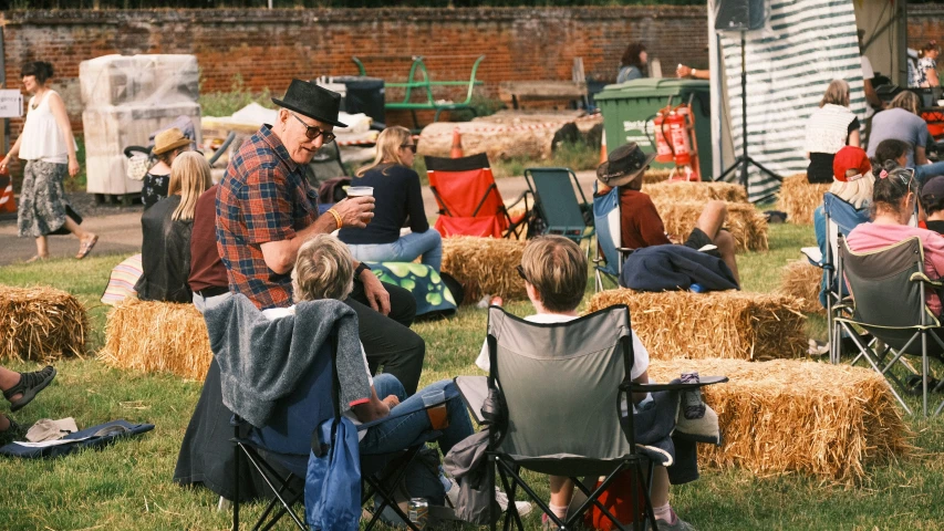 people are sitting on hay bales watching soing