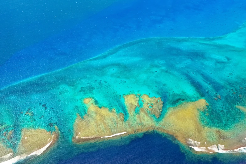 a sea view from the air of a blue lagoon surrounded by blue water