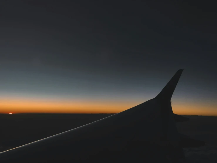 the view out an airplane window looking out at sunset