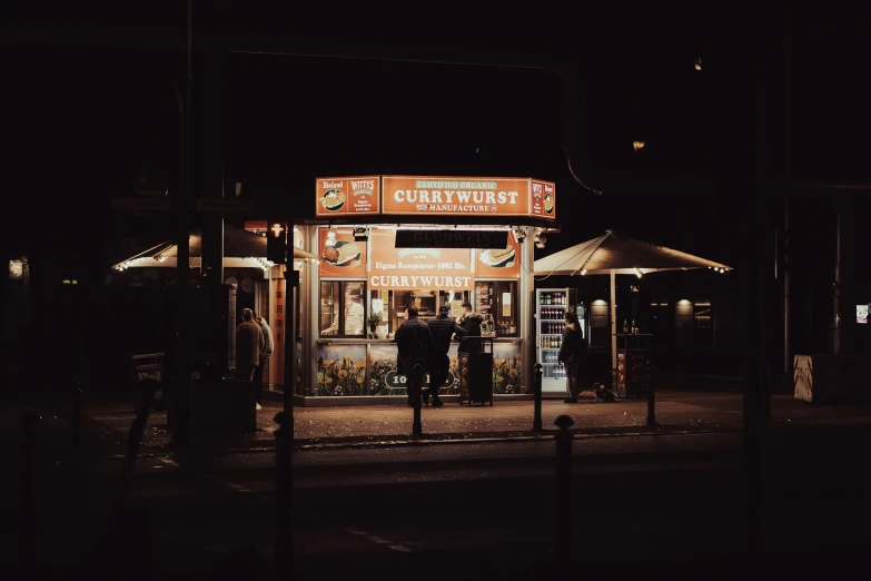 the night time shopfront has a light up sign above it