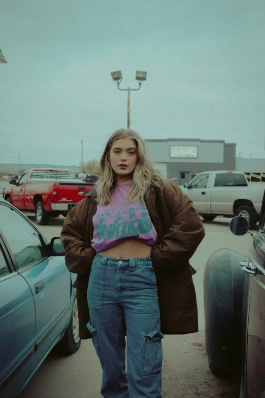 a woman standing next to cars in a parking lot