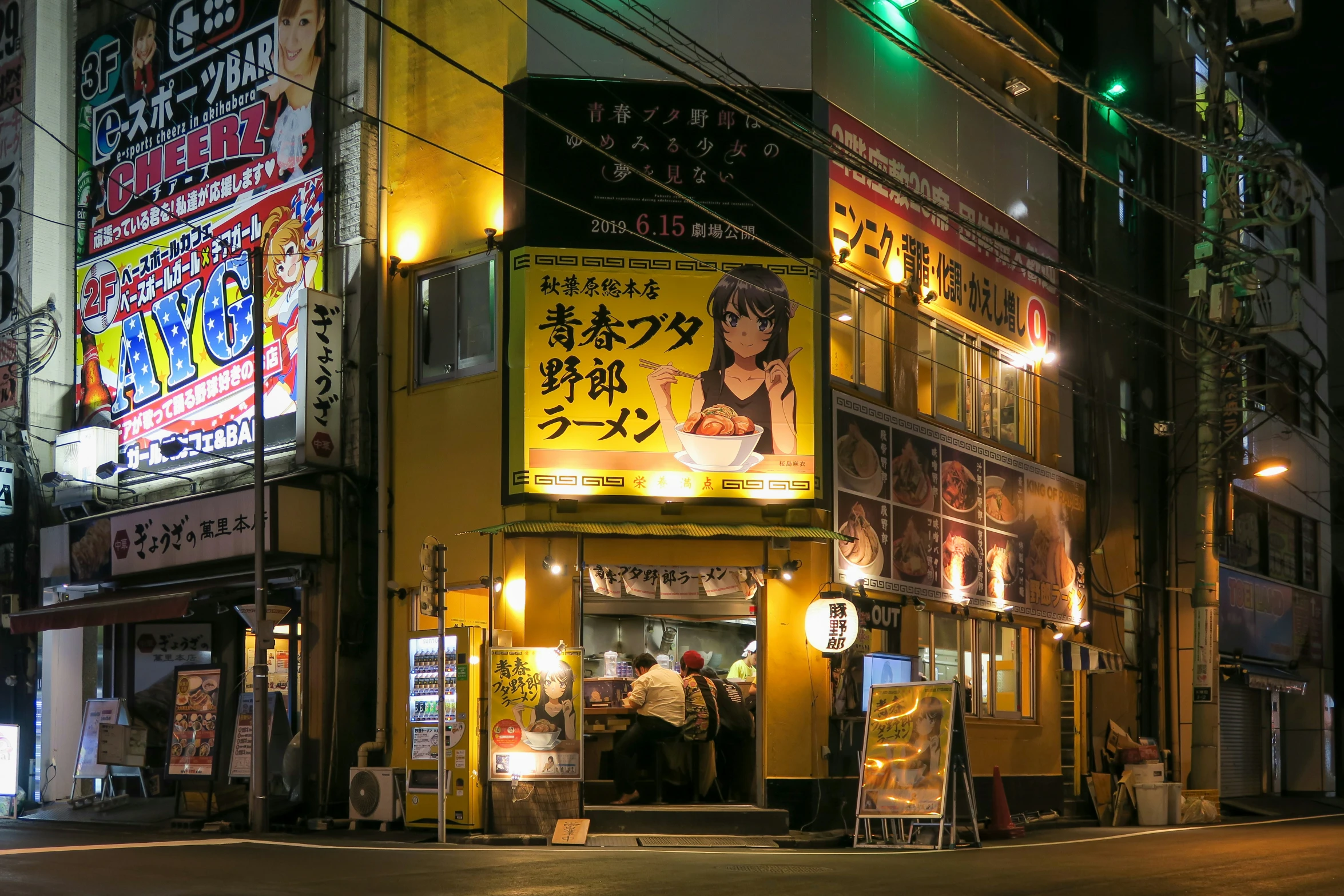 the corner of a street with a neon lit building