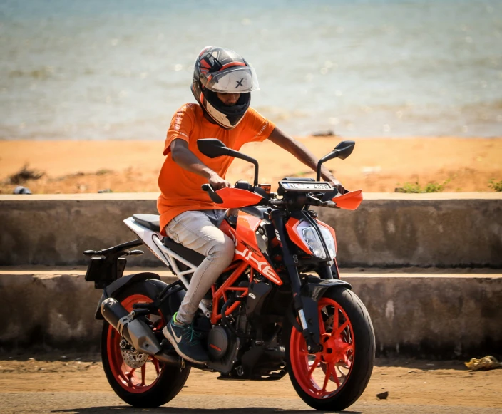 a guy riding a dirt bike by the sea