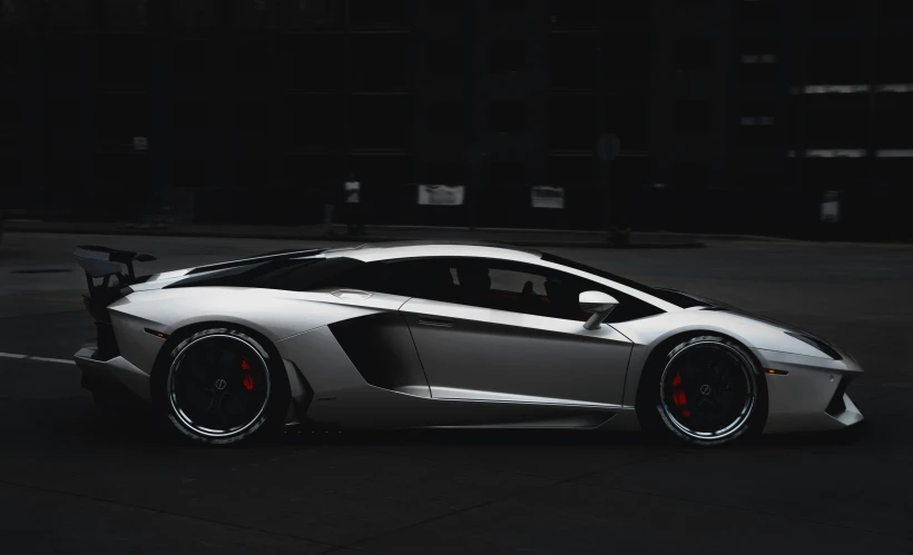 a large grey sports car is parked in a parking lot