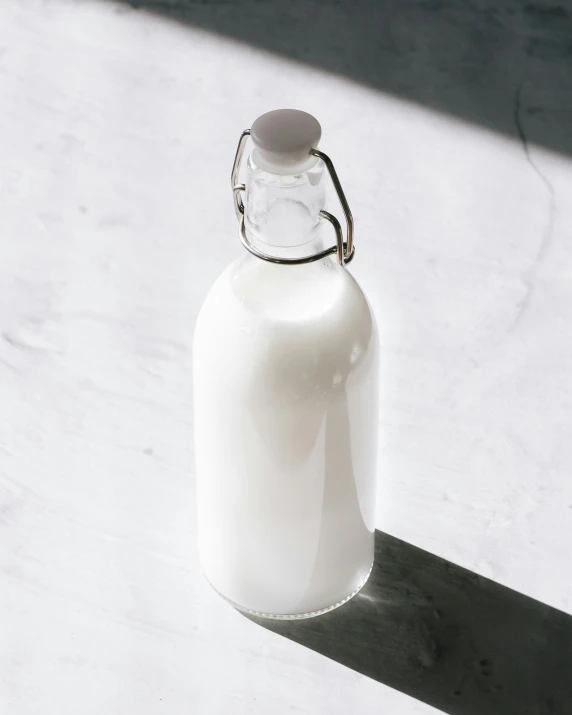 a white glass bottle on a light tiled surface