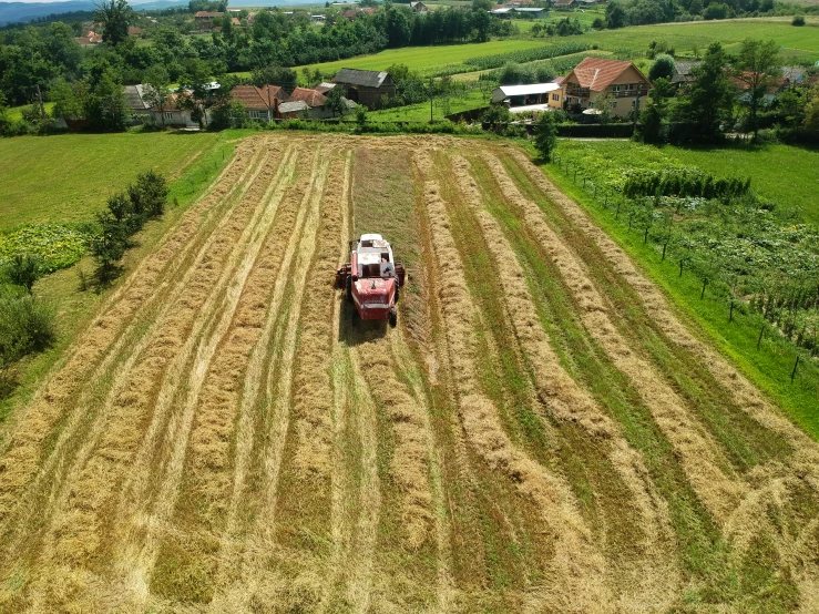 a large farm tractor driving through a field of grass